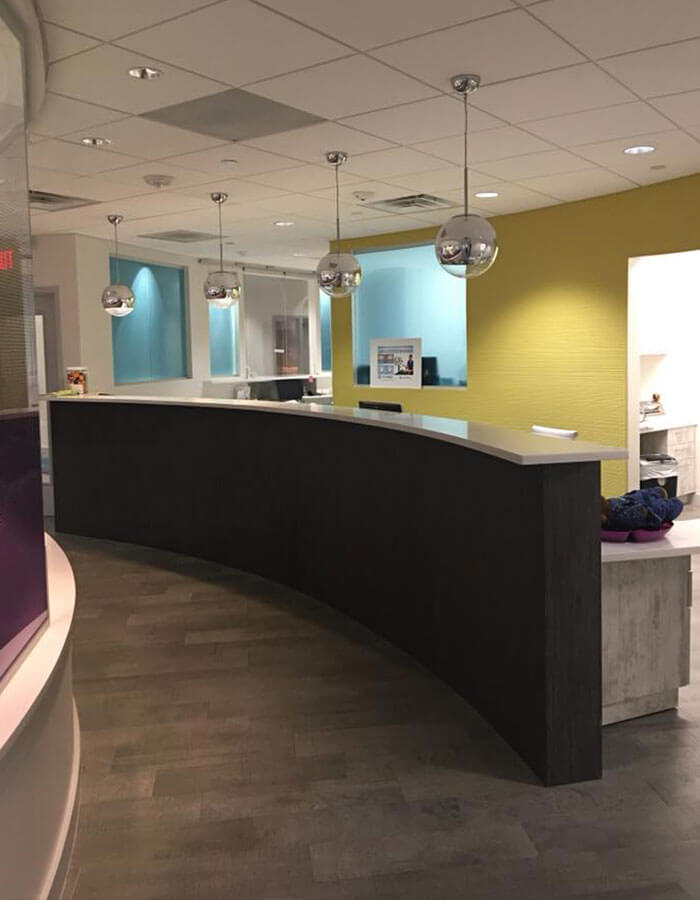 reception desk in dental office with four silver globe lights overhead