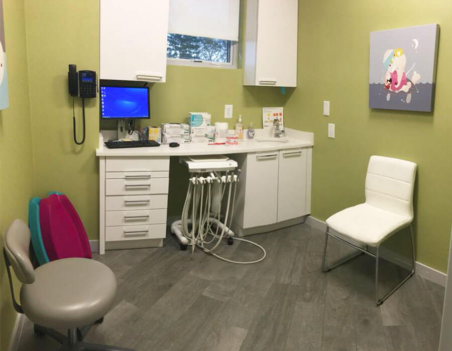 dental exam room with white desk and chairs and yellow walls