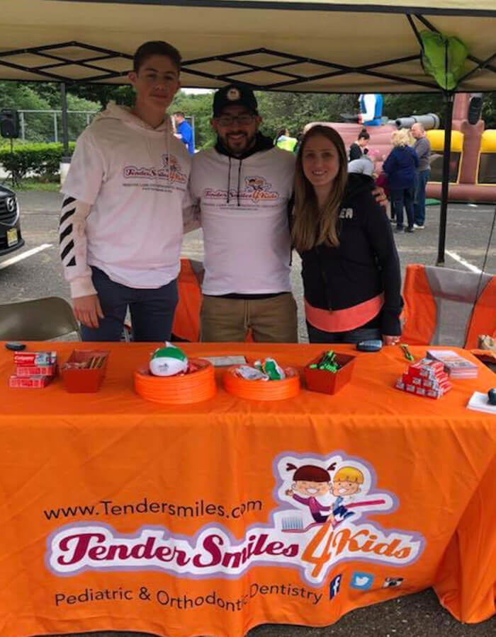 Tender Smiles 4 Kids booth set up at community event in parking lot