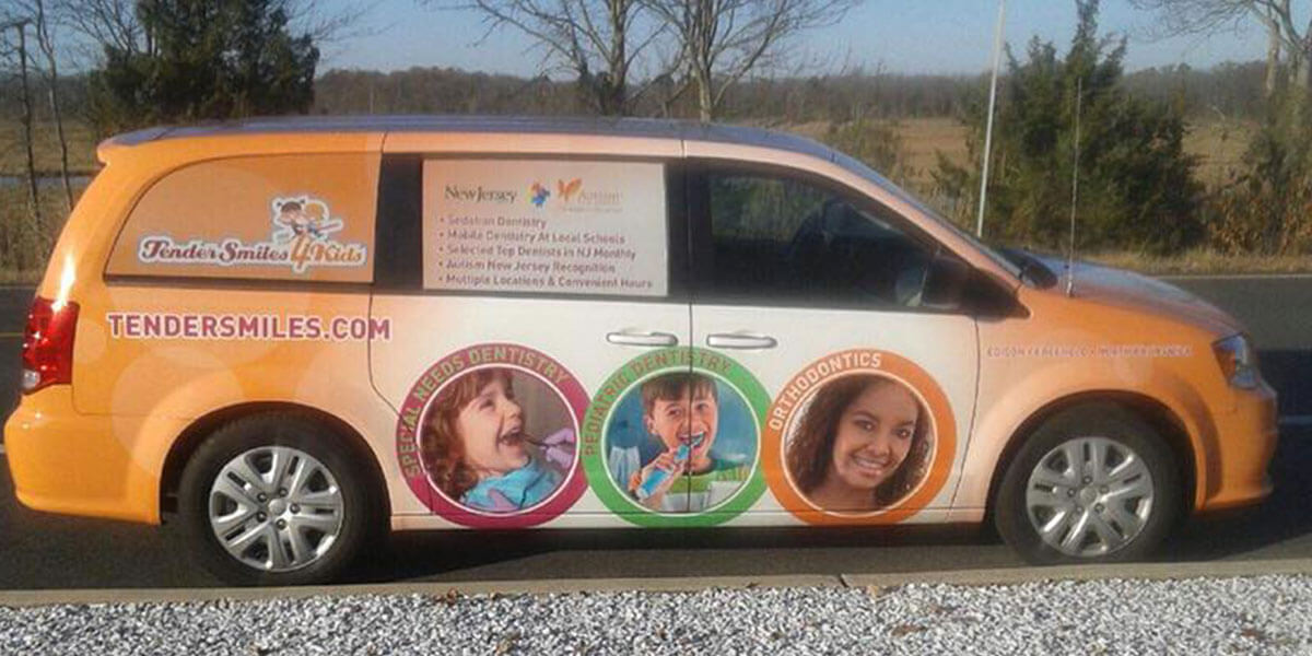 minivan wrapped in orange with Tender Smiles 4 Kids logo and dental information