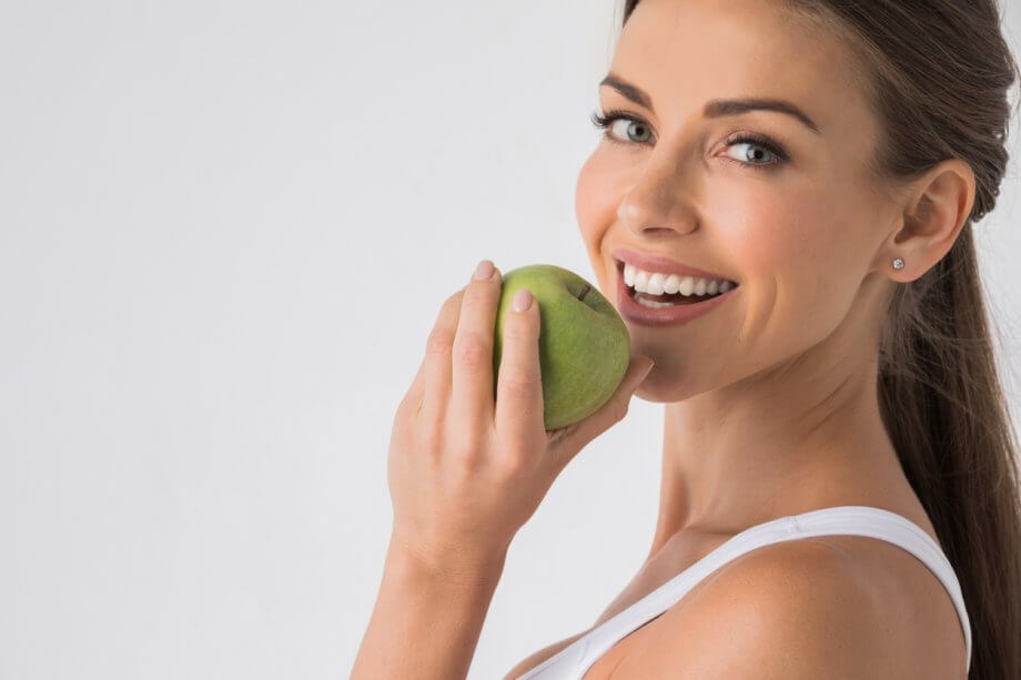 smiling woman biting apple