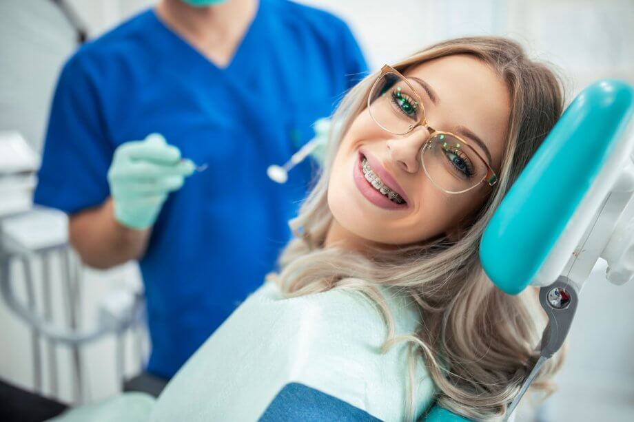 a girl with braces smiling in dental chair