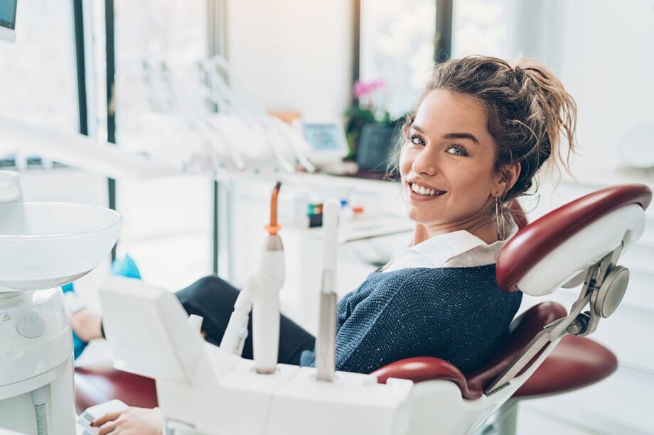 a woman smiles from a dental chair