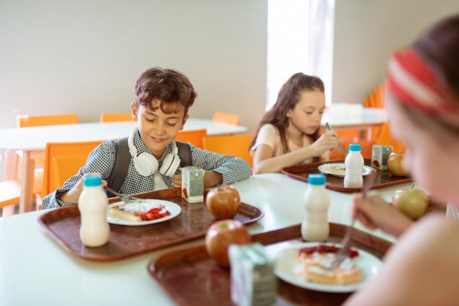 Schoolchildren Having Lunch in Cafeteria Together