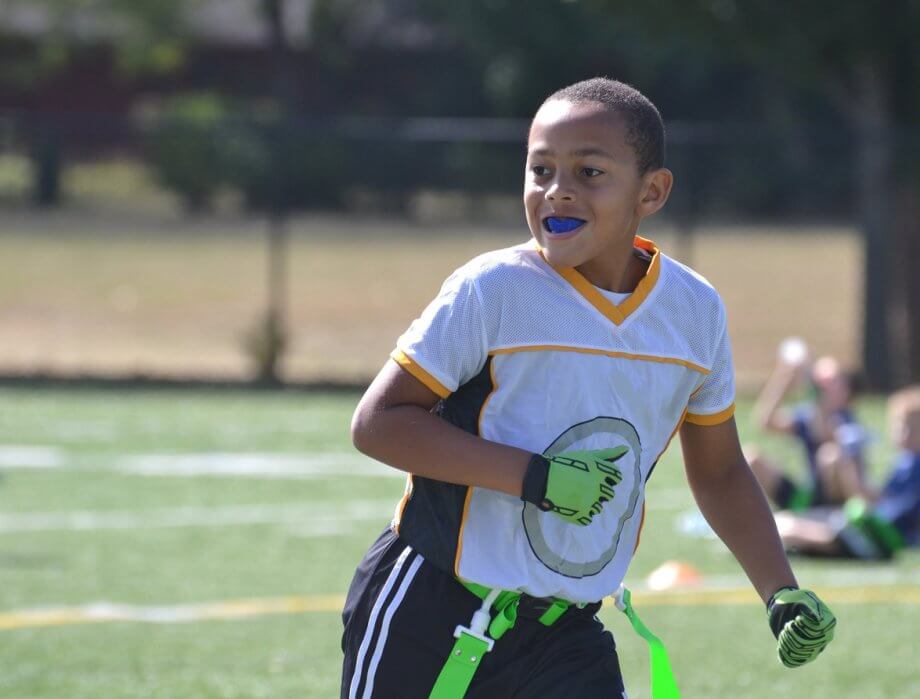 Young Child Playing Football Wearing Mouthguard