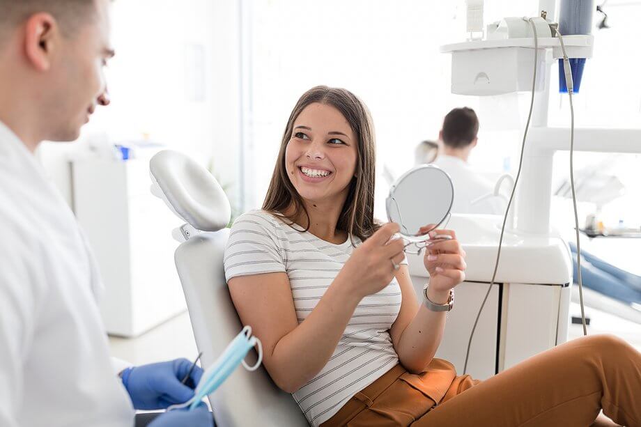 girl in dental chair smiles at dentist